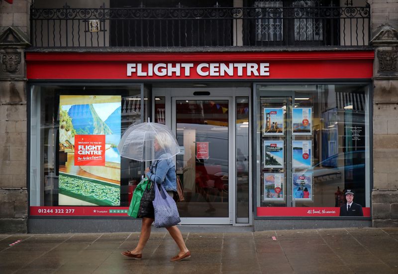 &copy; Reuters. FILE PHOTO: A woman walks past a Flight Centre travel agency, following the coronavirus disease (COVID-19) outbreak, in Chester, Britain, July 3, 2020. REUTERS/Molly Darlington/File photo