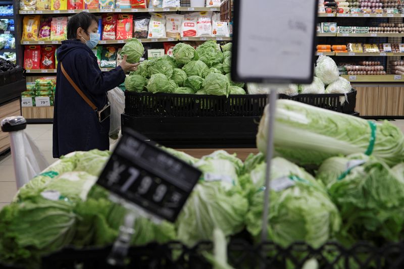 &copy; Reuters. FILE PHOTO: A customer shops for cabbages at the vegetable section of a supermarket in Beijing, China October 17, 2024. REUTERS/Florence Lo/File Photo