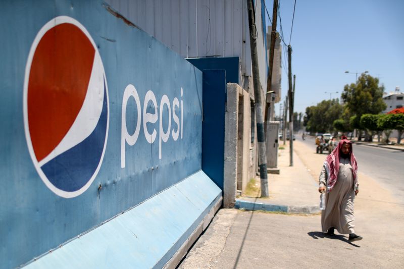 © Reuters. FILE PHOTO: A Palestinian man walks past Gaza Pepsi factory for soft drinks in Gaza City June 21, 2021. REUTERS/Mohammed Salem/File Photo