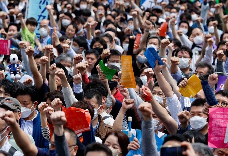 © Reuters. FILE PHOTO: Members of the Japanese Trade Union Confederation, commonly known as Rengo, raise their fists as they shout Gambaro and cheer during their annual May Day rally to demand higher pay and better working conditions, in Tokyo, Japan April 29, 2023. REUTERS/Issei Kato/File Photo