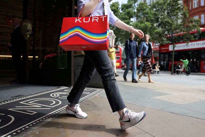 © Reuters. FILE PHOTO: A shopper walks with a shopping bag outside a Kurt Geiger retail store on Oxford Street in London, Britain, August 27, 2024. REUTERS/Hollie Adams/File Photo