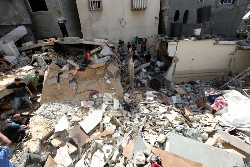 © Reuters. Palestinians inspect the site of an Israeli strike on a house, amid the ongoing Israel-Hamas conflict, in Al Maghazi refugee camp in the central Gaza Strip, October 19, 2024. REUTERS/Ramadan Abed