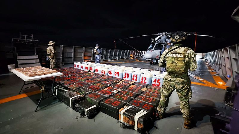 © Reuters. Members of the Mexican Navy stand guard next to packages on display after seizing some 8.4 thousand kilograms of illicit cargo and arresting 23 people in an operation off the country's southwestern Pacific coast, near Lazaro Cardenas, Michoacan, Mexico, in this undated handout photo released on October 18, 2024.  Mexican Navy/Handout via REUTERS