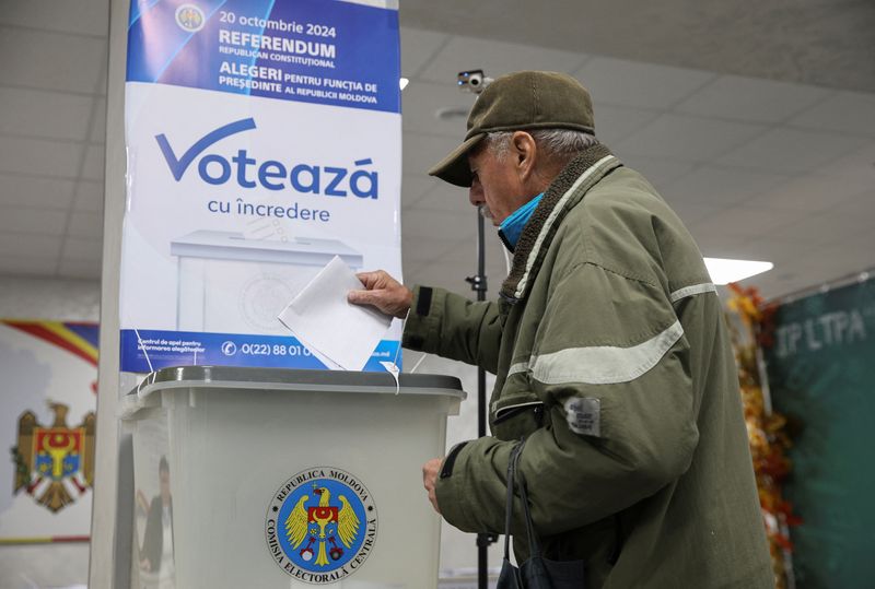 © Reuters. A voter casts a ballot at a polling station, as the country holds a presidential election and a referendum on joining the European Union, in Chisinau, Moldova October 20, 2024. REUTERS/Vladislav Culiomza