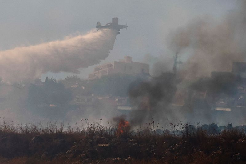 © Reuters. An Israeli airplane extinguishes fire following a rocket impact, amid cross-border hostilities between Hezbollah and Israel, near Rosh Pina, northern Israel, October 20, 2024. REUTERS/Gonzalo Fuentes