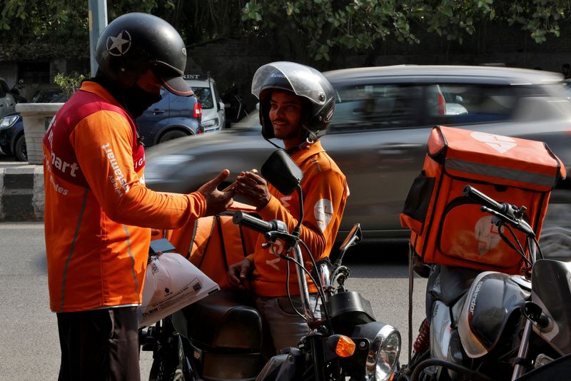 © Reuters. FILE PHOTO: Gig workers prepare to deliver orders outside Swiggy's grocery warehouse at a market area in New Delhi, India, May 6, 2024. REUTERS/Priyanshu Singh/File Photo