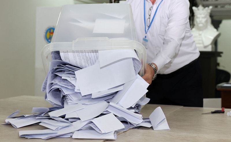 © Reuters. A member of an electoral commission empties a ballot box after polling stations closed in the course of Moldova's presidential election and a referendum on joining the European Union, in Chisinau, Moldova October 20, 2024. REUTERS/Stringer