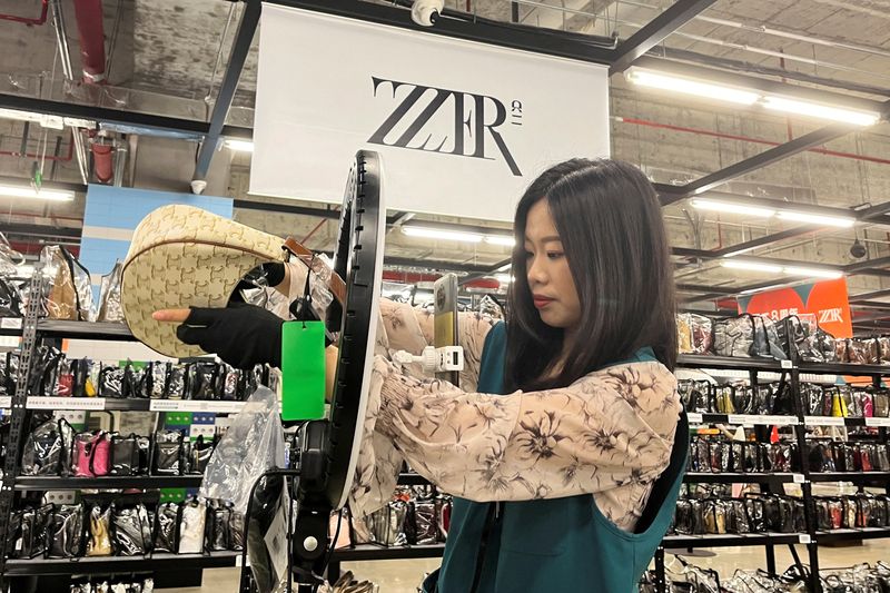 &copy; Reuters. FILE PHOTO: A host promotes a bag during a live streaming session at a warehouse of second-hand luxury e-commerce platform ZZER in Shanghai, China July 5, 2023. REUTERS/Xihao Jiang/File Photo