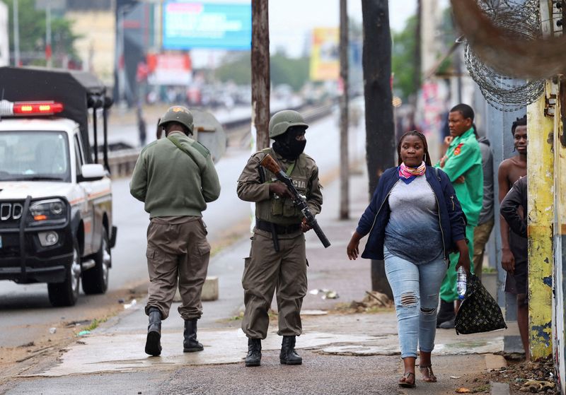 &copy; Reuters. A woman walks past a police officer, during a nationwide strike called by Mozambique presidential candidate Venancio Mondlane to protest the provisional results of an October 9 election, in Maputo, Mozambique, October 21, 2024. REUTERS/Siphiwe Sibeko    