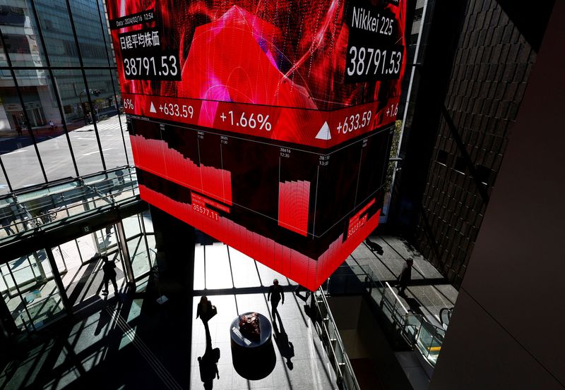 &copy; Reuters. Visitors walk under a huge screen displaying Japan's Nikkei share average inside a building in Tokyo, Japan February 16, 2024.  REUTERS/Issei Kato/ File Photo