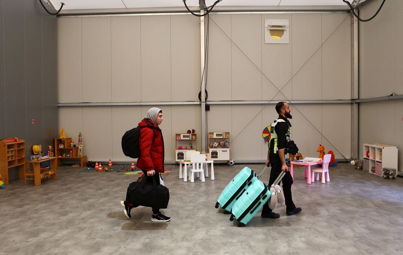 &copy; Reuters. FILE PHOTO: A security member helps to move the belongings of a family fleeing the Russian attack on Ukraine after their arrival at a temporary refugee shelter in Hanau, Germany, March 2, 2023.  REUTERS/Kai Pfaffenbach