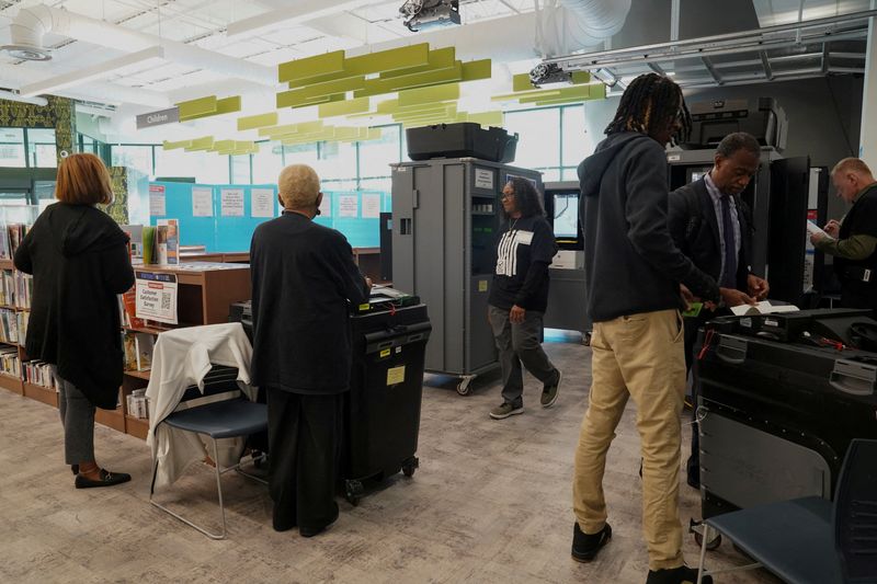 © Reuters. FILE PHOTO: People stand inside a polling station as Georgians turned out a day after the battleground state opened early voting, in Atlanta, Georgia, U.S., October 16, 2024. REUTERS/Megan Varner/File photo