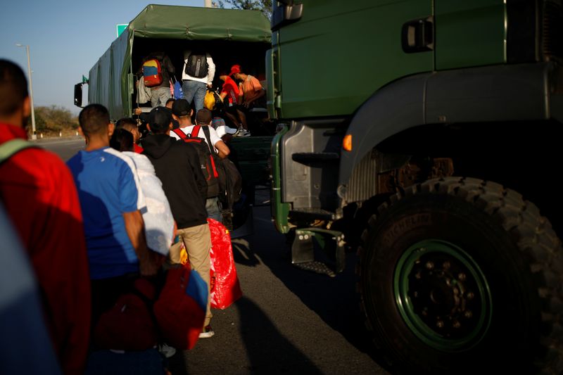 © Reuters. FILE PHOTO: Venezuelan migrants get on military trucks to get a free ride from the Ecuadorian-Peruvian border service to Tumbes, after processing their documents, on the outskirts of Tumbes, Peru June 15, 2019. Picture taken June 15, 2019. REUTERS/Carlos Garcia Rawlins/File Photo