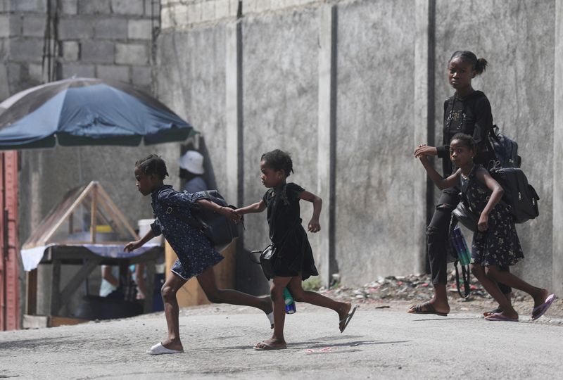 &copy; Reuters. FILE PHOTO: A woman and three children flee their home from gang violence, in Port-au-Prince, Haiti October 20, 2024. REUTERS/Ralph Tedy Erol/File Photo