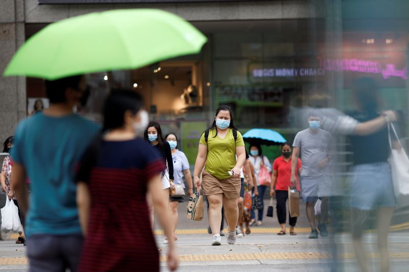 © Reuters. People wearing protective face masks cross a street, amid the coronavirus disease (COVID-19) outbreak, in Singapore July 14, 2020. REUTERS/Edgar Su/ File Photo