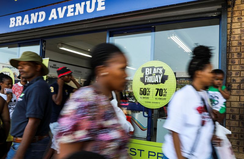 © Reuters. Shoppers walk past a shop window displaying Black Friday signage at Woodmead Value Mart, in Johannesburg, South Africa, November 25, 2023. REUTERS/Sumaya Hisham/ File Photo