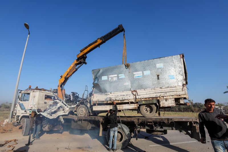 © Reuters. Palestinians work to remove an UNRWA-labelled vehicle after it was hit in an Israeli strike, according to Palestinian officials, amid the Israel-Hamas conflict, in Deir Al-Balah in the central Gaza Strip, October 23, 2024. REUTERS/Ramadan Abed