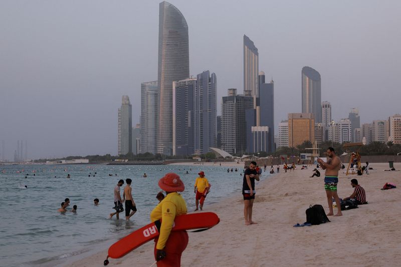 © Reuters. FILE PHOTO: A lifeguard stands while people enjoy on the beach with a skyline visible in the background, in Abu Dhabi, United Arab Emirates, September 27, 2023. REUTERS/Amr Alfiky/File Photo