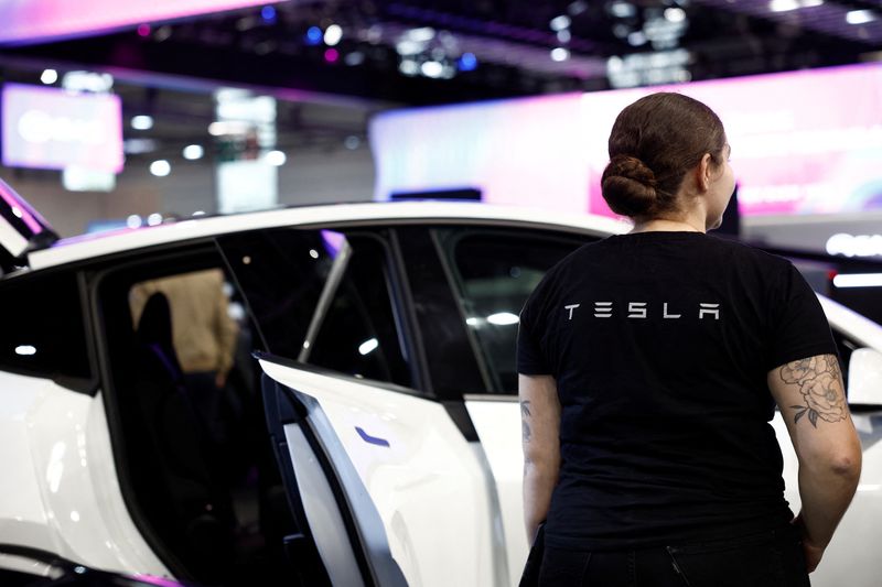 &copy; Reuters. FILE PHOTO: The name of the brand Tesla is seen on the back of an employee on media day at the 2024 Paris Auto Show in Paris, France, October 14, 2024. REUTERS/Benoit Tessier/File Photo