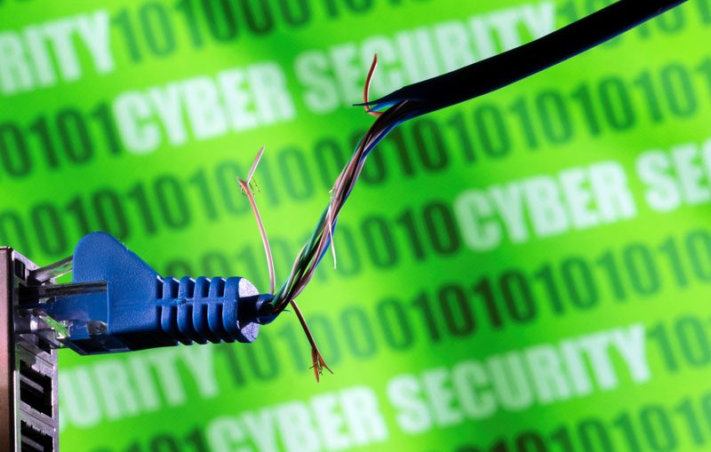 © Reuters. Broken Ethernet cable is seen in front of binary code and words 