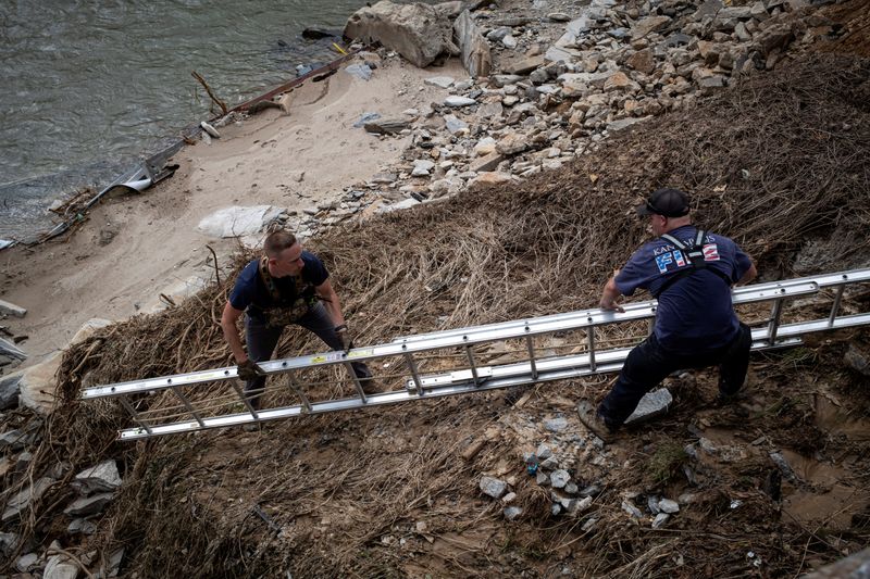 &copy; Reuters. FILE PHOTO: Fire and Rescue members set up a ladder to go down on Broad River riverbank, following the passing of Hurricane Helene, in Bat Cave, North Carolina, U.S., September 30, 2024. REUTERS/Marco Bello/File Photo