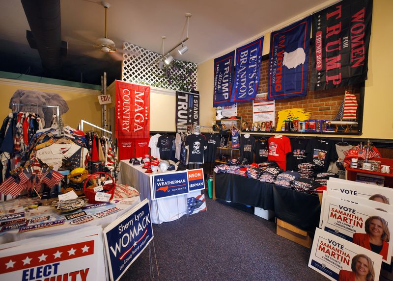 © Reuters. Merchandise in support of Republican presidential nominee and former U.S. President Donald Trump mingles with state and local election signs and other material at the Republican Party headquarters for Lee County, in Sanford, North Carolina, U.S. October 16, 2024. REUTERS/Jonathan Drake