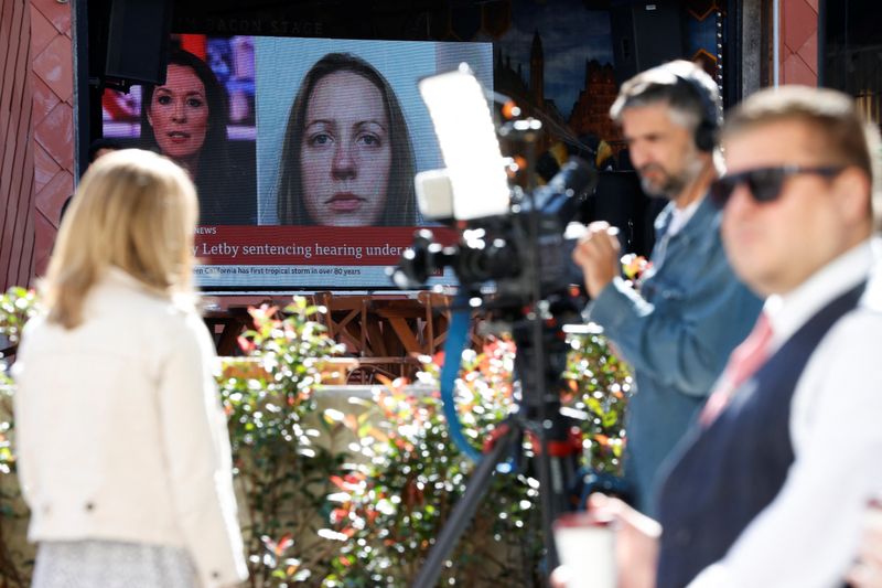 © Reuters. FILE PHOTO: Members of the media work near a large screen showing a picture of convicted hospital nurse Lucy Letby, ahead of her sentencing, outside the Manchester Crown Court, in Manchester, Britain, August 21, 2023. REUTERS/Phil Noble/File Photo