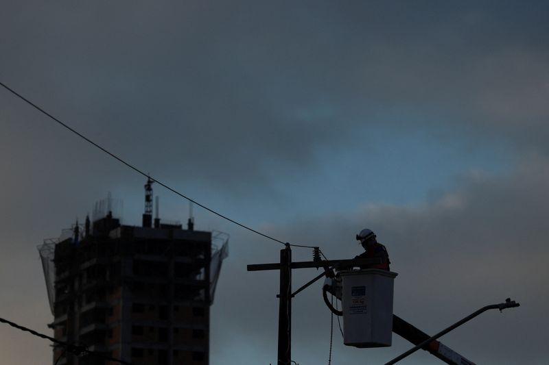 &copy; Reuters. FILE PHOTO: A man works on a pole to restore electricity after a storm knocked down power cables in Sao Paulo, Brazil November 6, 2023. REUTERS/Carla Carniel/File Photo