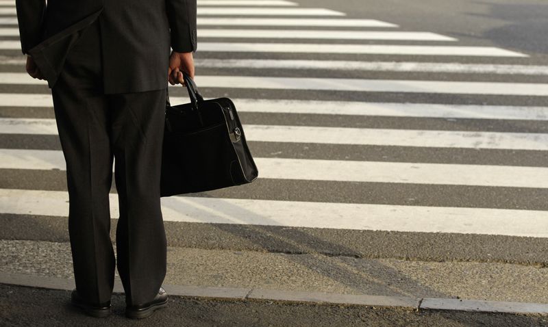 © Reuters. FILE PHOTO: A businessman waits to cross a street in Tokyo April 4, 2011.  REUTERS/Yuriko Nakao/File Photo