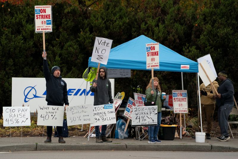 &copy; Reuters. Boeing workers from the International Association of Machinists and Aerospace Workers District 751 gather on a picket line near the entrance to a Boeing production facility on the day of a vote on a new contract proposal during an ongoing strike in Renton