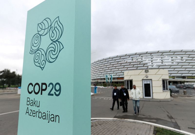 © Reuters. FILE PHOTO: People walk near the Baku Olympic Stadium, the venue of the COP29 United Nations Climate Change Conference, in Baku, Azerbaijan October 18, 2024. REUTERS/Aziz Karimov/File Photo