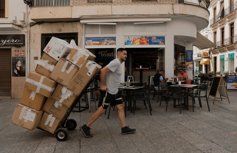 © Reuters. A delivery worker pulls a cart with boxes on a street, in Ronda, Spain October 1, 2024. REUTERS/Jon Nazca/ File Photo