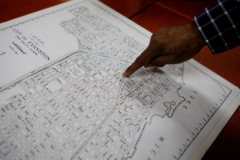 © Reuters. FILE PHOTO: Community historian Morris “Dino” Robinson, who helped shape the Evanston’s reparations initiative, points to the borders of the Fifth Ward, which was the area of Evanston the city’s Black citizens were forced to move to due to redlining between 1919 and 1969, in Evanston, Illinois, U.S March 17, 2021. REUTERS/Eileen T. Meslar/File Photo