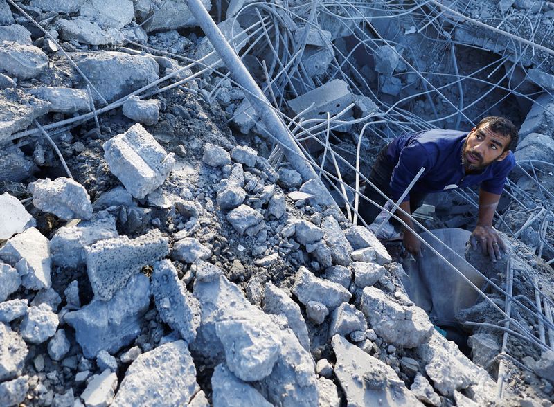 © Reuters. A Palestinian inspects the site of an Israeli strike on a house, in Khan Younis in the southern Gaza Strip October 25, 2024. REUTERS/Mohammed Salem 