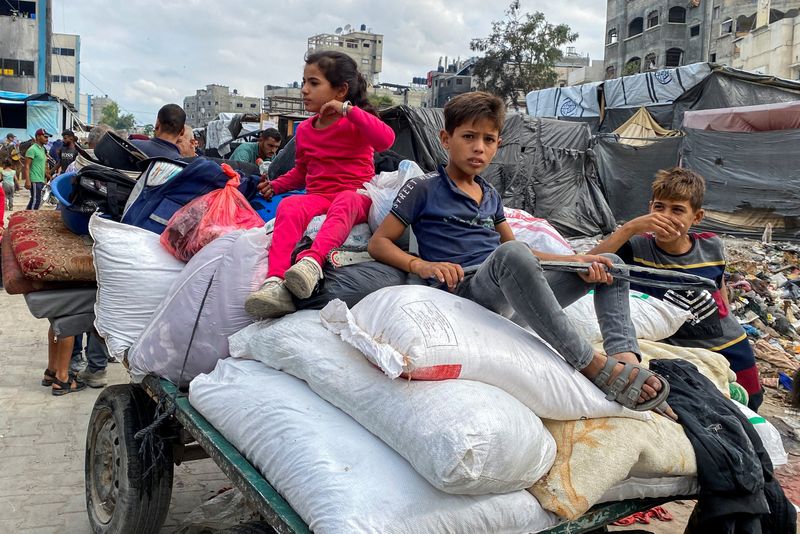 &copy; Reuters. Crianças palestinas desalojadas em carroça durante retirada de regiões do norte de Gaza após ordem de retirada da regiãon06/10/2024 REUTERS/Hussam Al-Zaanin