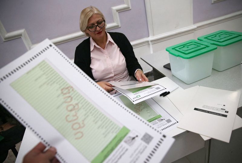 &copy; Reuters. FILE PHOTO: A member of an electoral commission arranges sample ballots at a polling station on the eve of the parliamentary elections in Tbilisi, Georgia October 25, 2024. REUTERS/Irakli Gedenidze/File Photo