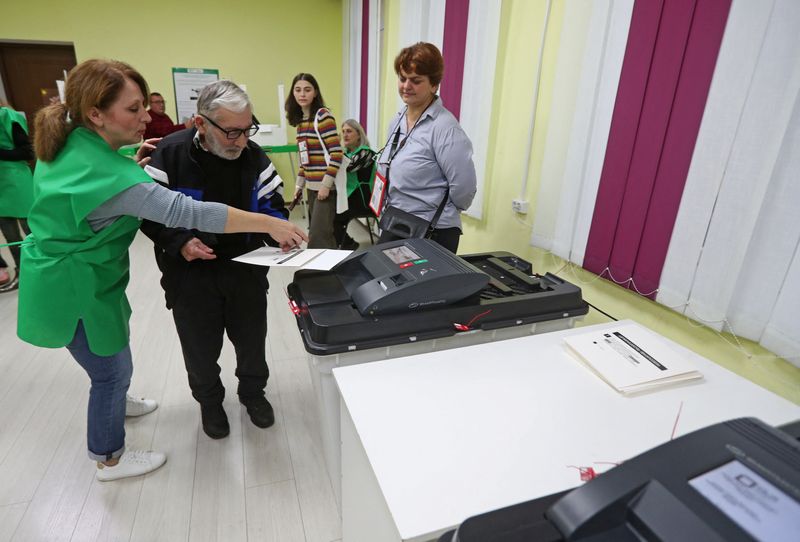 © Reuters. A voter casts his ballot at a polling station during parliamentary elections in Tbilisi, Georgia October 26, 2024. REUTERS/Irakli Gedenidze