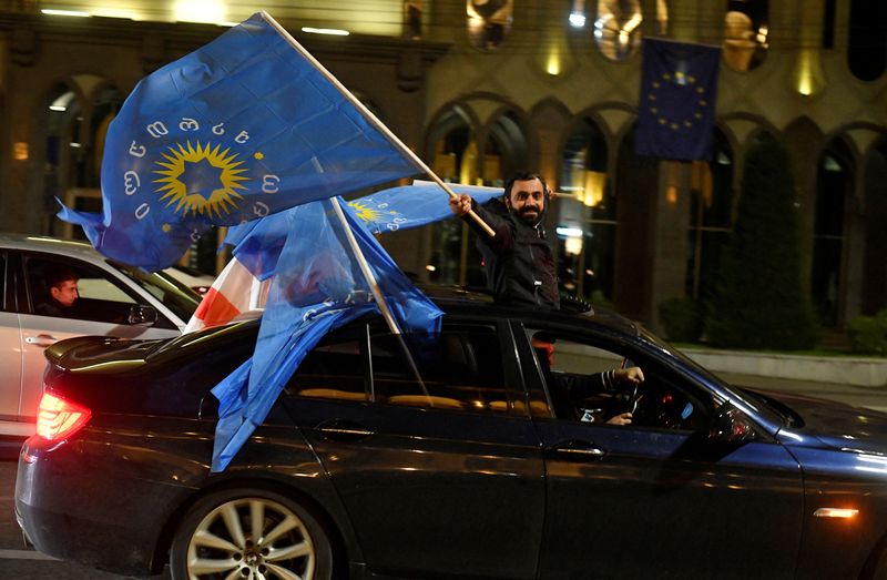 © Reuters. A supporter of the Georgian Dream party waves the party's flags, Tbilisi, October 26, 2024. REUTERS/Zurab Javakhadze