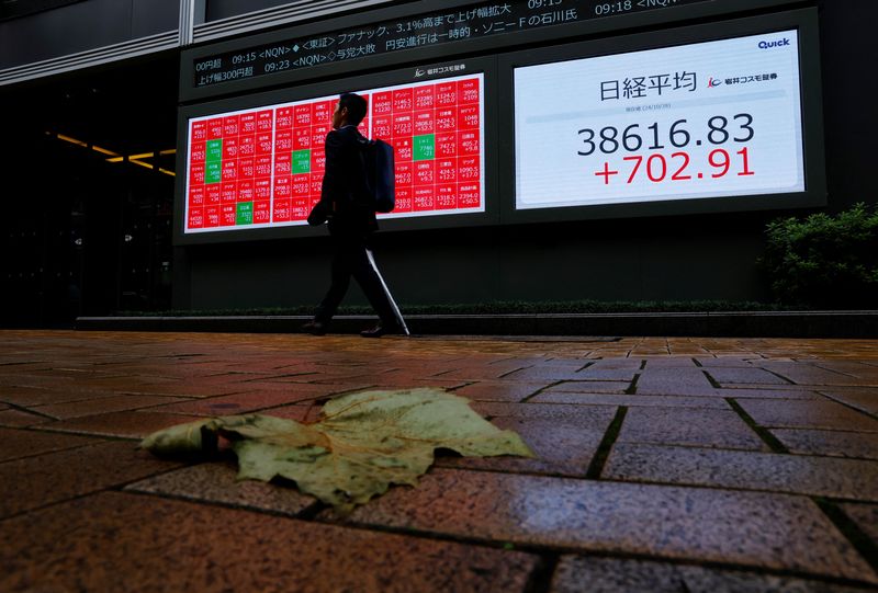 © Reuters. A passerby walks past an electronic screen displaying the Nikkei stock average outside a brokerage in Tokyo, Japan October 28, 2024. REUTERS/Kim Kyung-Hoon