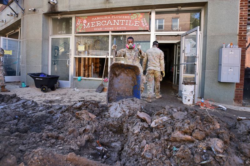 © Reuters. FILE PHOTO: U.S. Army infantry soldiers from the 101st Airborne Division help clear mud from a severely flooded business on Main Street in the aftermath of Hurricane Helene, in Marshall, North Carolina, U.S. October 10, 2024.  REUTERS/Jonathan Drake/File Photo