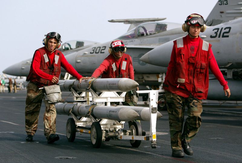 © Reuters. AIM-120 AMRAAM air-to-air intercept missiles are wheeled past fighter jets on the deck of the USS Kitty Hawk in the northern Persian Gulf March 10, 2003/File Photo