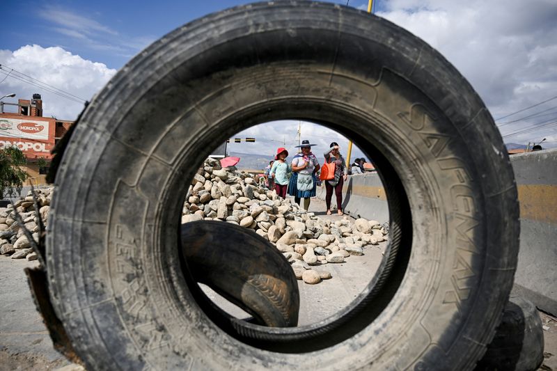 © Reuters. People cross a blockade set up in support of former Bolivian President Evo Morales, protesting against the government of President Luis Arce, in Puente Khora, Cochabamba, Bolivia October 28, 2024. REUTERS/Claudia Morales