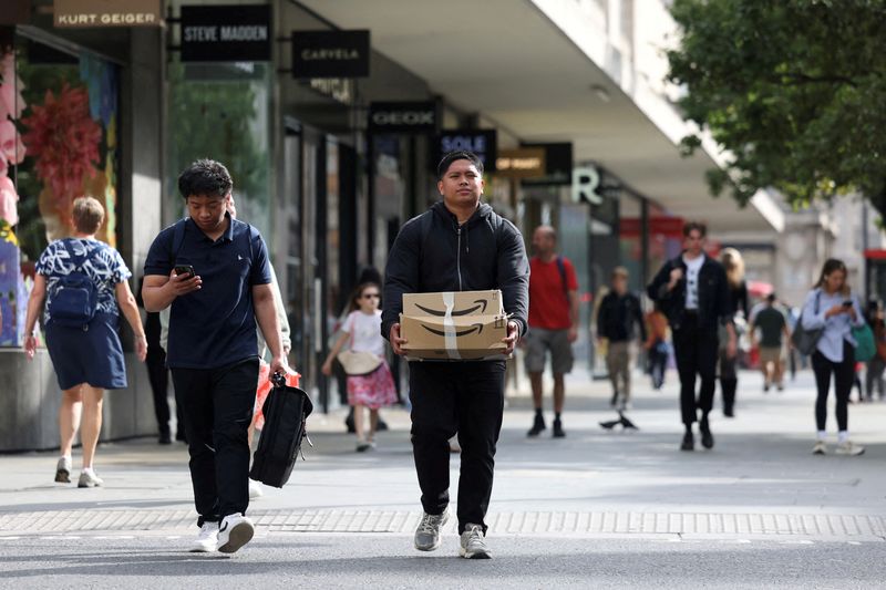 &copy; Reuters. FILE PHOTO: A person carries an Amazon box past retail stores on Oxford Street in London, Britain, August 27, 2024. REUTERS/Hollie Adams/File Photo