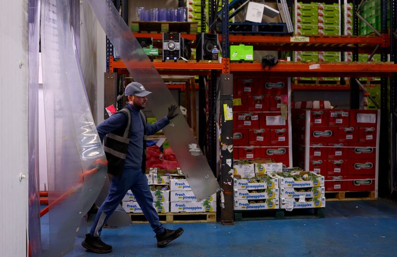 © Reuters. FILE PHOTO: A worker moves pallets of fruit during early morning business hours at New Covent Garden Market in London, Britain, October 8, 2024. REUTERS/Hannah McKay/File Photo