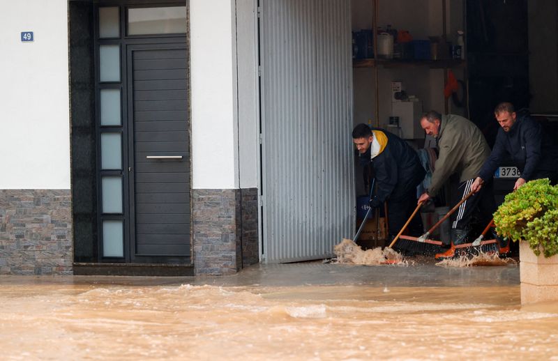 © Reuters. People remove water from a residence after the Spanish meteorological agency put the Valencia region in the highest red alert for extreme rainfalls, in Llombai, Valencia, Spain, October 29, 2024. REUTERS/Eva Manez