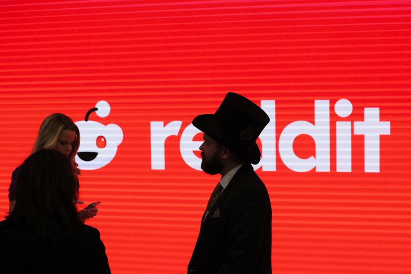 © Reuters. People stand in front of Reddit's logo, at the New York Stock Exchange (NYSE) in New York City, U.S., March 21, 2024. REUTERS/Brendan McDermid/File Photo