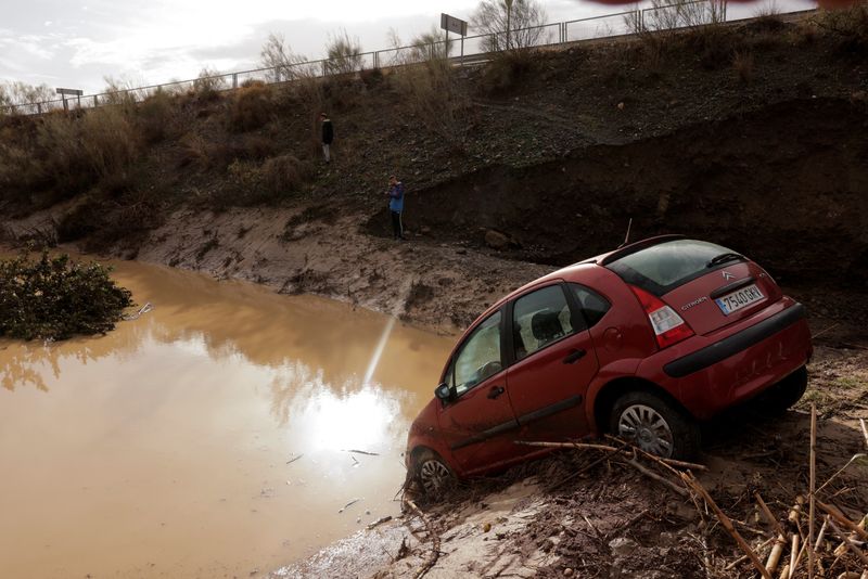 &copy; Reuters. People stand in a flooded area after heavy rains and floods in Alora, Spain October 29, 2024. REUTERS/Jon Nazca