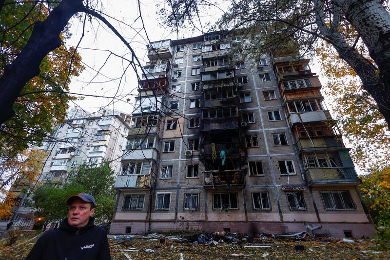 © Reuters. A resident stands in front of an apartment building damaged by a Russian drone strike, amid Russia's attack on Ukraine, in Kyiv, Ukraine October 30, 2024. REUTERS/Valentyn Ogirenko