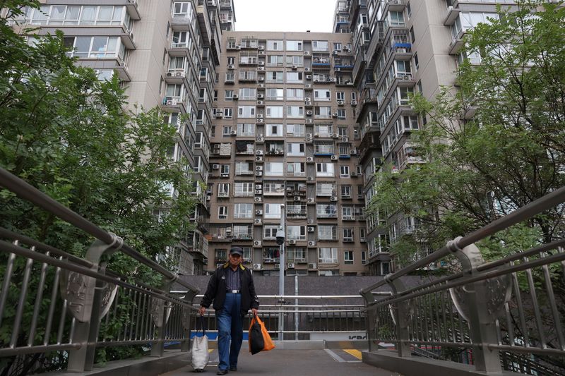 © Reuters. FILE PHOTO: A man walks on a pedestrian bridge near residential buildings in Beijing, China October 17, 2024. REUTERS/Florence Lo/File Photo