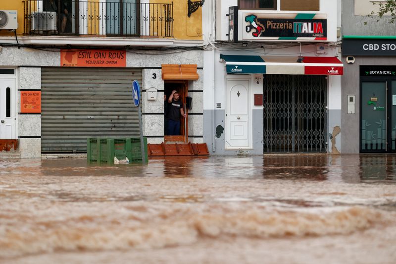 © Reuters. A person reacts to heavy flooding on a street after the Spanish meteorological agency put the Valencia region in the highest red alert for extreme rainfalls, in Llombai, Valencia, Spain, October 29, 2024. REUTERS/Eva Manez